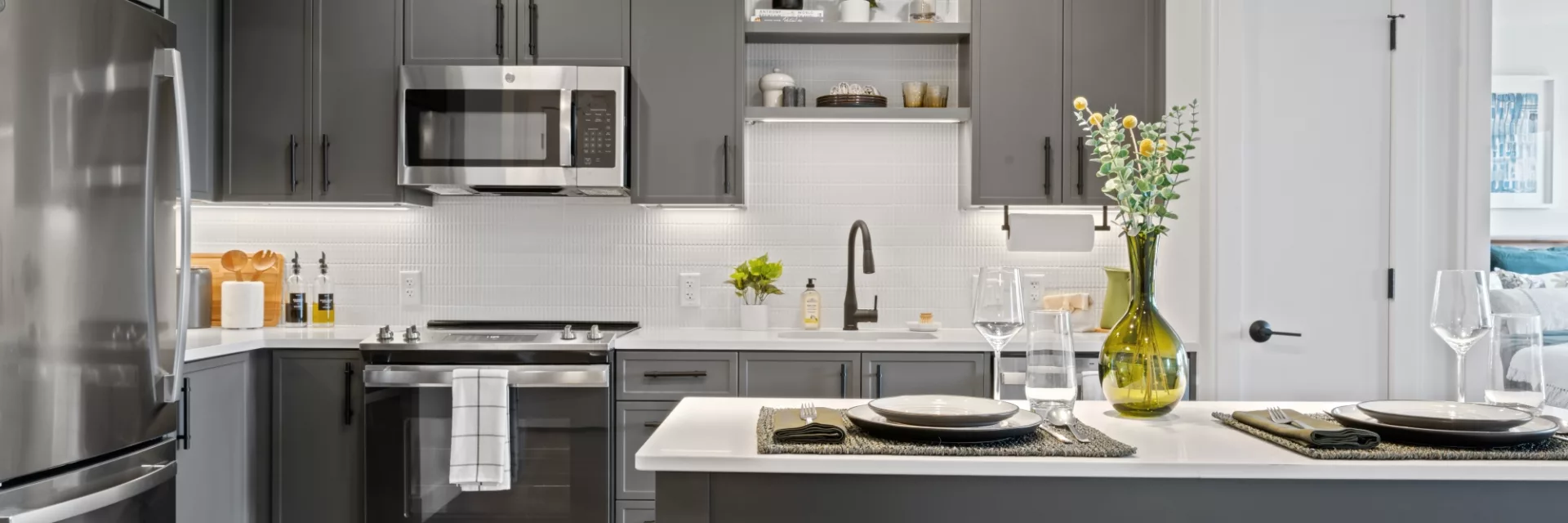 Kitchen with Caesarstone quartz countertops with tiled backsplashes and under-cabinet lighting