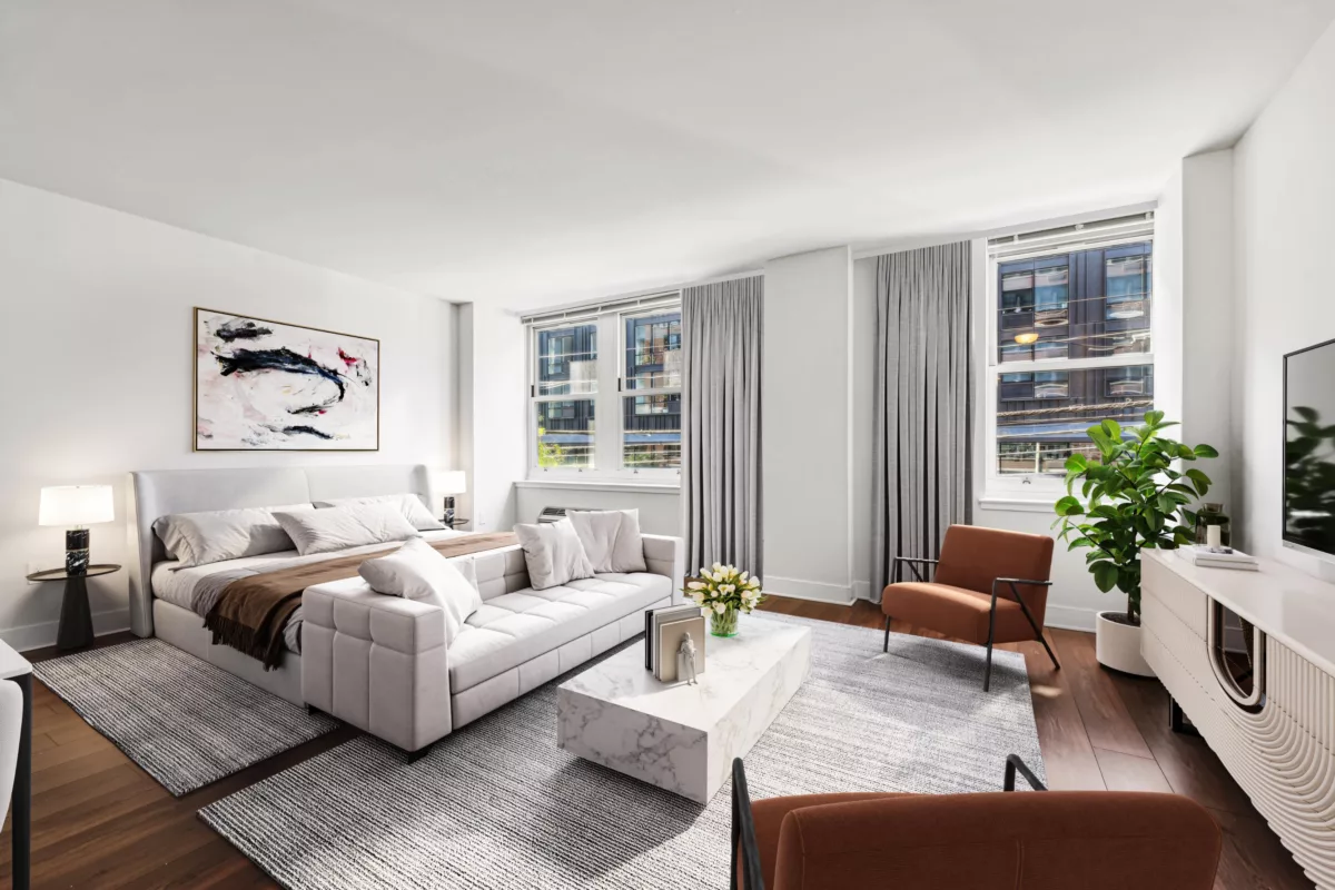 Living room with white sofa and large windows overlooking a city skyline.