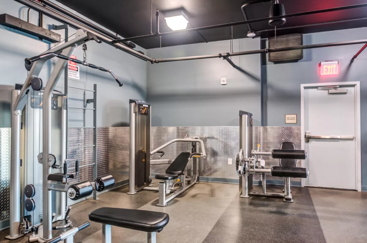 Indoor gym area with weight machines and metal wall accents.