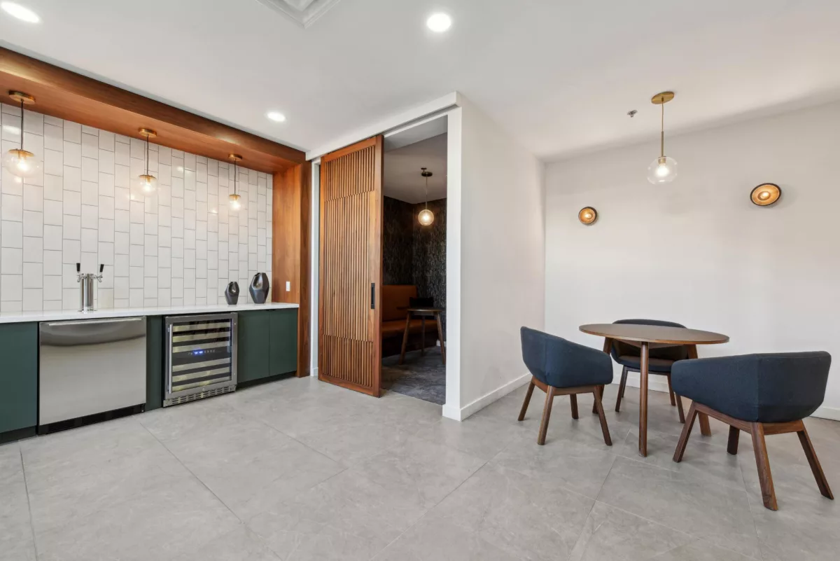 Lounge with tiled bar area, round dining table, and booth seating alcove.