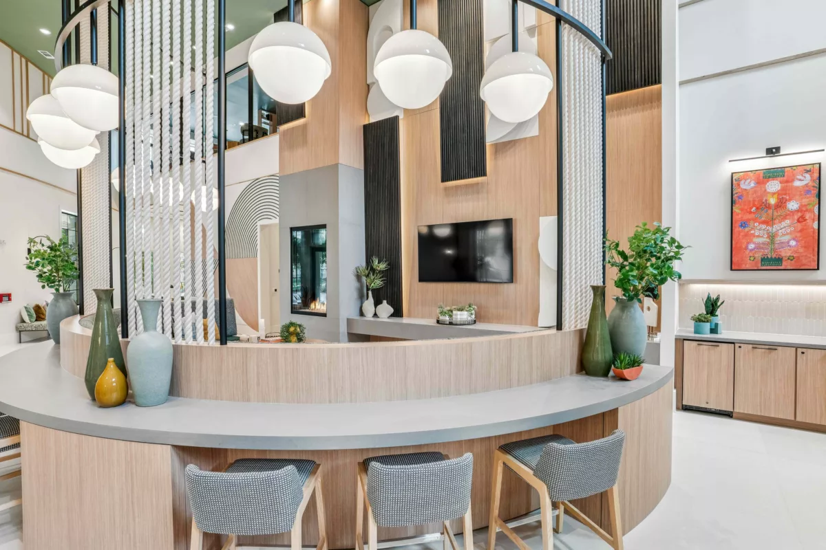 Clubroom with curved bar, stools, decorative vases, a TV, and a fireplace.