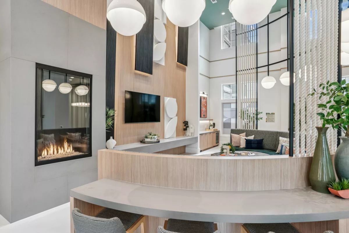 Clubroom with fireplace, TV, seating, and high ceilings with globe pendant lights.