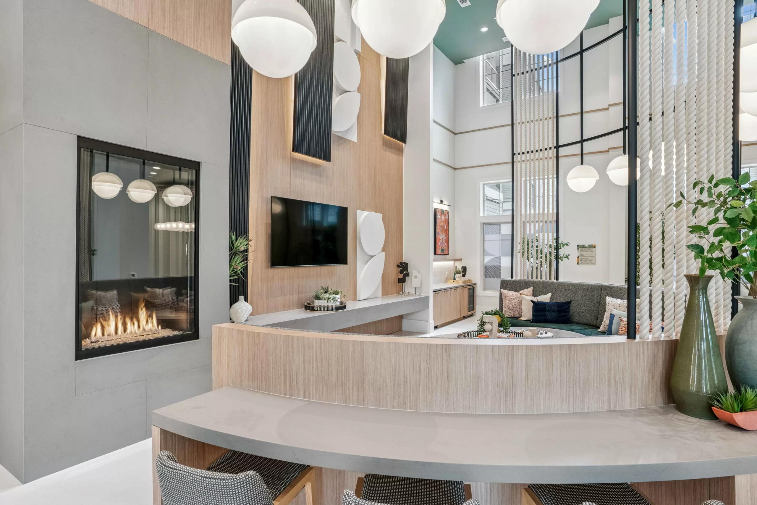 Clubroom with fireplace, TV, seating, and high ceilings with globe pendant lights.