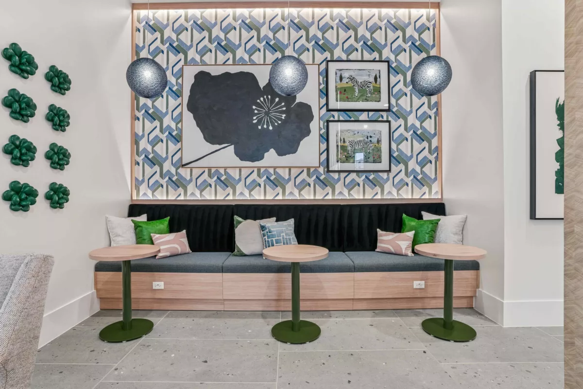 Resident bar lounge area with built-in seating, small tables, and decorative wall art.