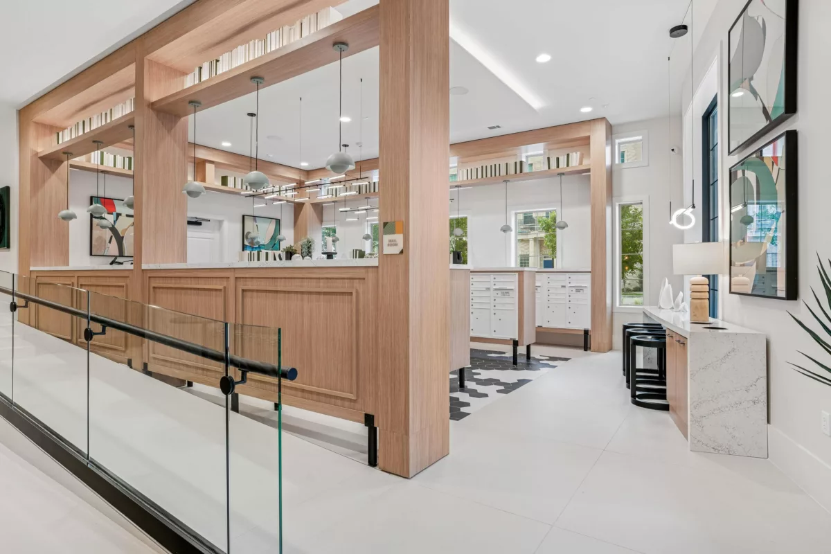 Social mailroom with wood accents, mailboxes, and seating area.