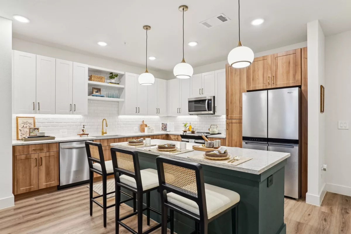 Modern kitchen with two-tone cabinets, island seating, and pendant lighting over island.