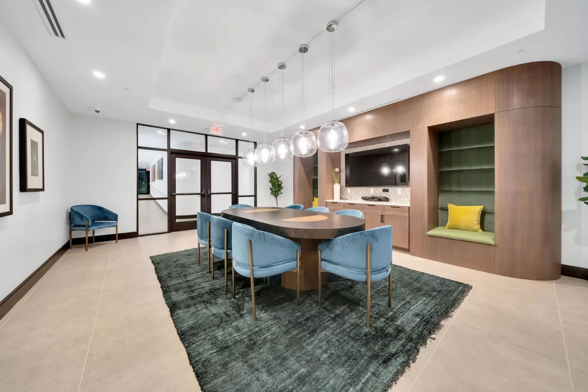 Meeting room with oval table, blue chairs, wood paneling, and built-in seating nook.