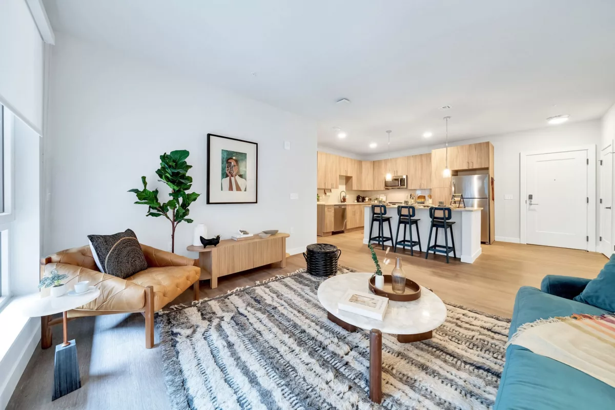 Open-concept living area with wood floors, kitchen island, and modern furnishings.