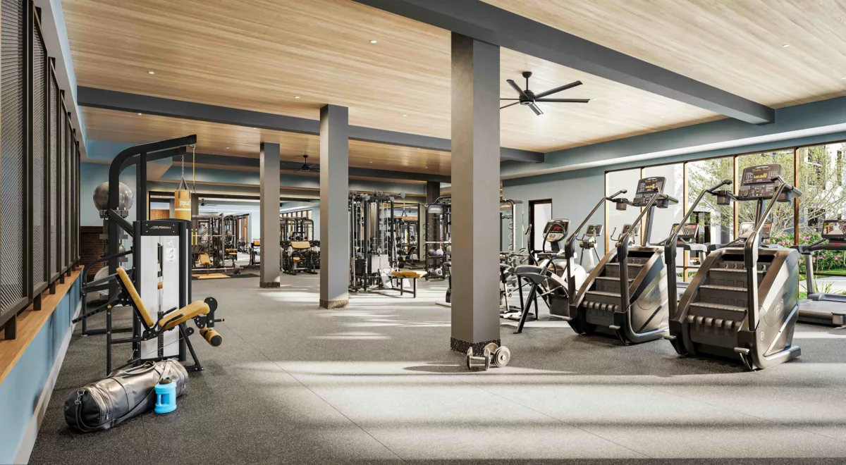 Well-equipped gym with stair climbers, strength training machines, large windows, and natural light.