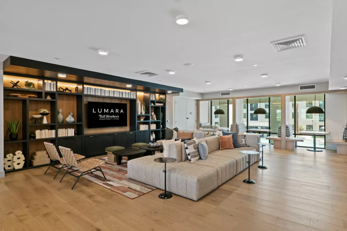 Lounge area with large sectional sofa, built-in shelving, and wood floors.