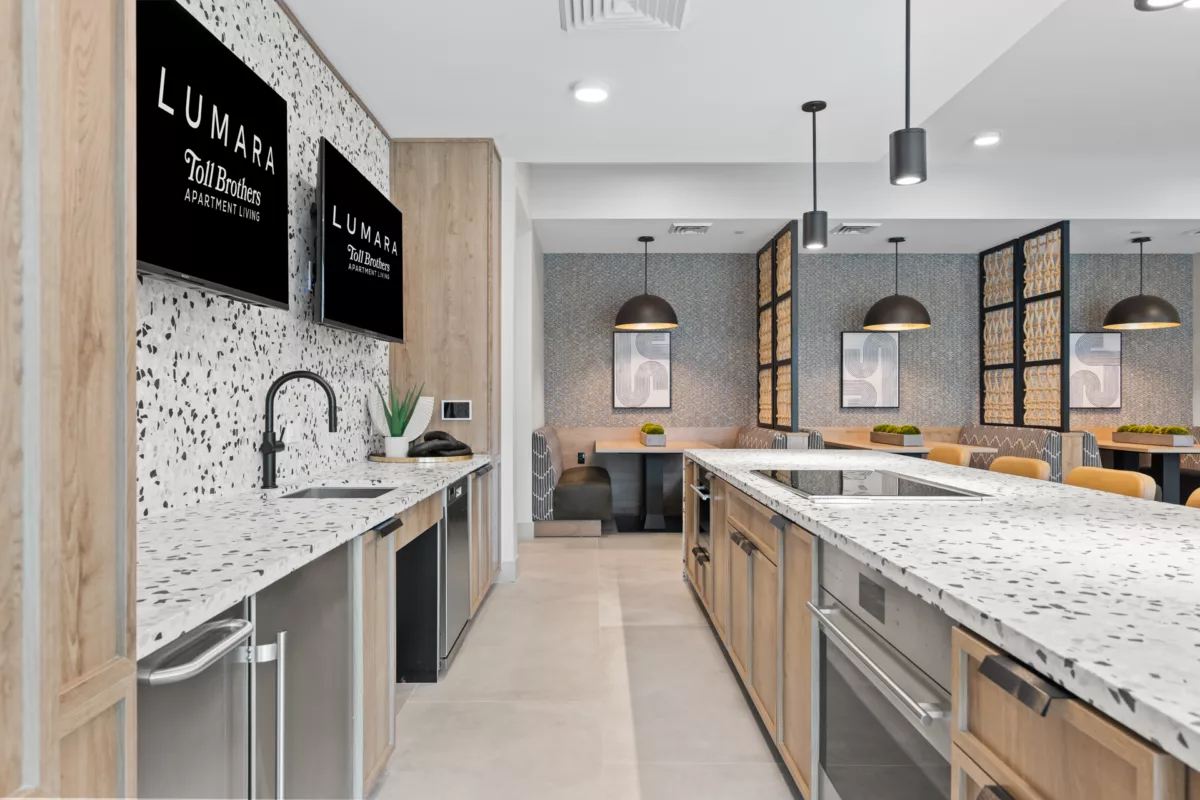 Community kitchen with island, banquette seating, and modern pendant lighting.