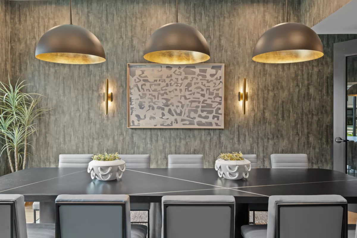 Dining area with black table, gray chairs, pendant lights, and textured wallpaper.
