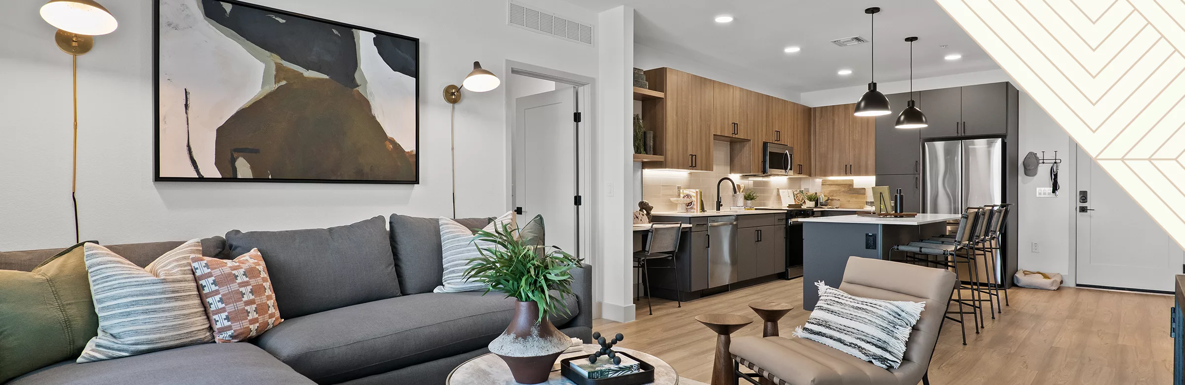 A photo of a living room and kitchen with a decorative triangle in the upper right corner.