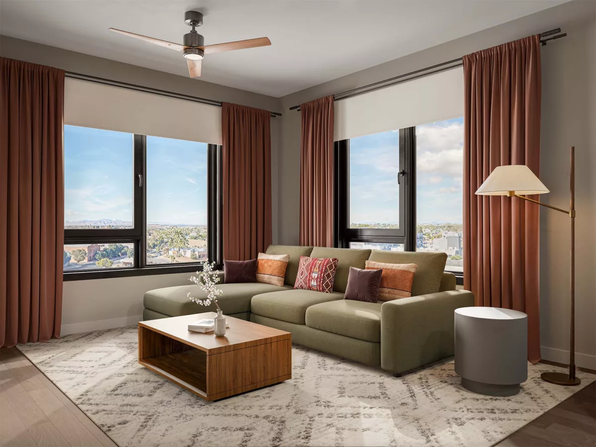 Modern living room with sectional sofa, wood table, and large windows with city views.
