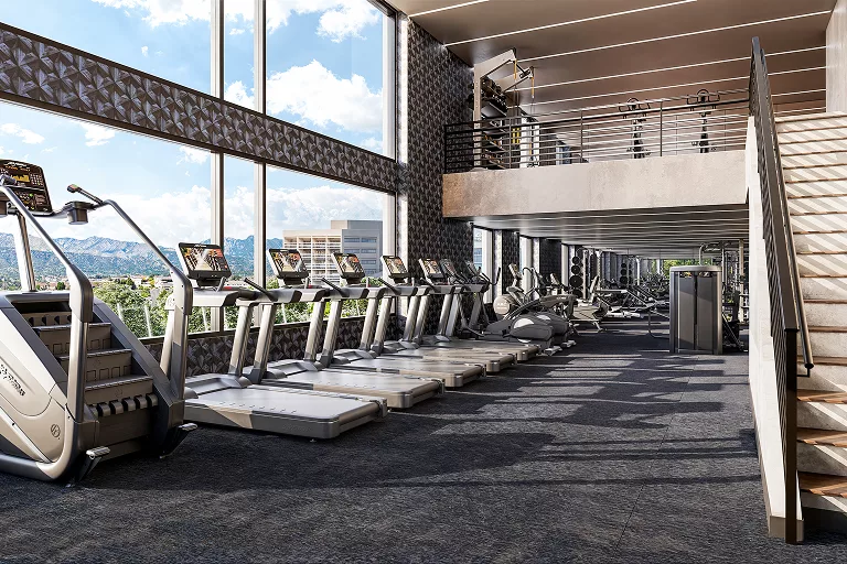 Modern gym with treadmills, stair climber, and mountain views