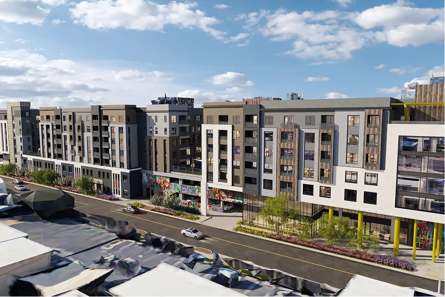 Mid-rise apartment building in sunlight with city skyline in background
