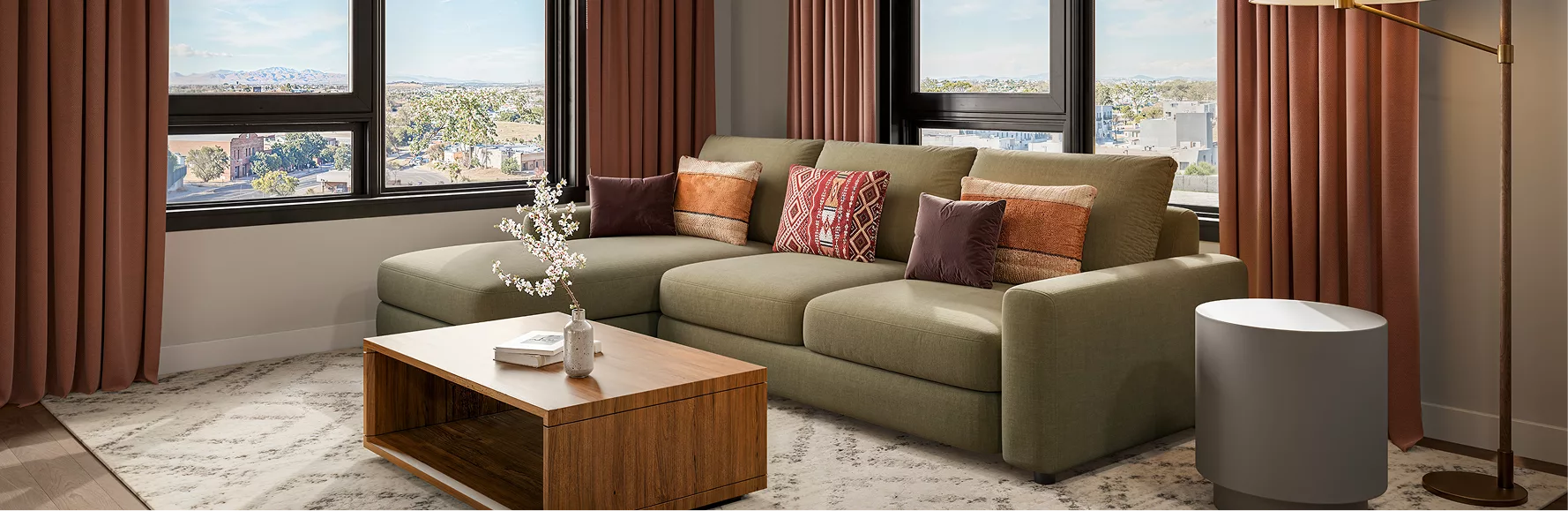 Modern kitchen and living room with bar seating and green sectional sofa