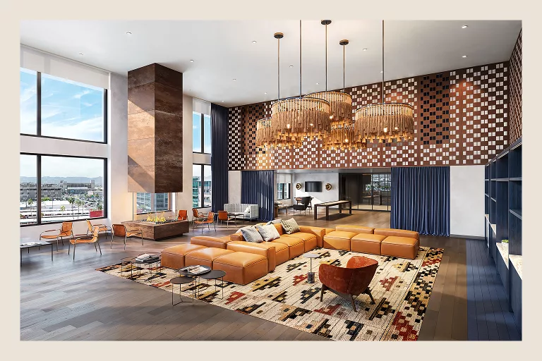 Spacious lounge with leather sofas, large windows, and chandeliers