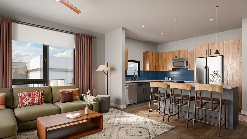 Cozy seating area with green sectional, wood table, and large windows