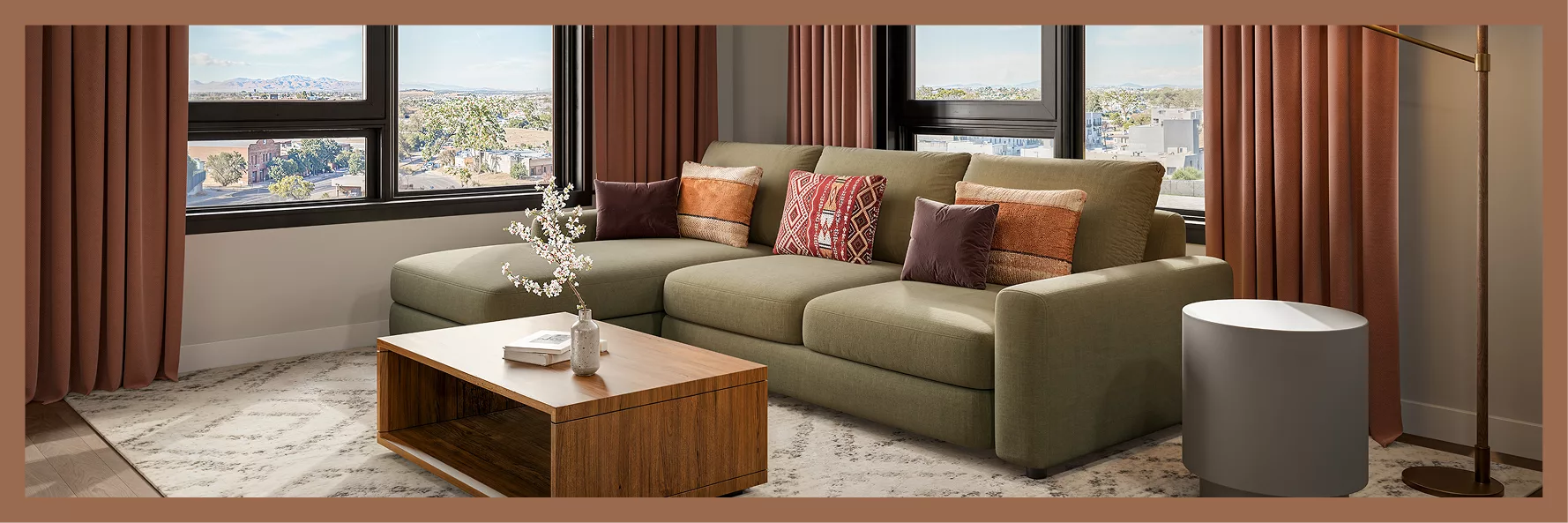 Modern kitchen and living room with bar seating and green sectional sofa