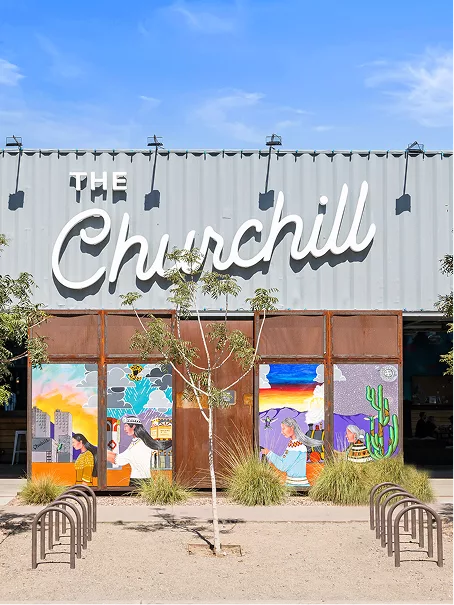 Colorful murals and “The Churchill” sign on modern building exterior