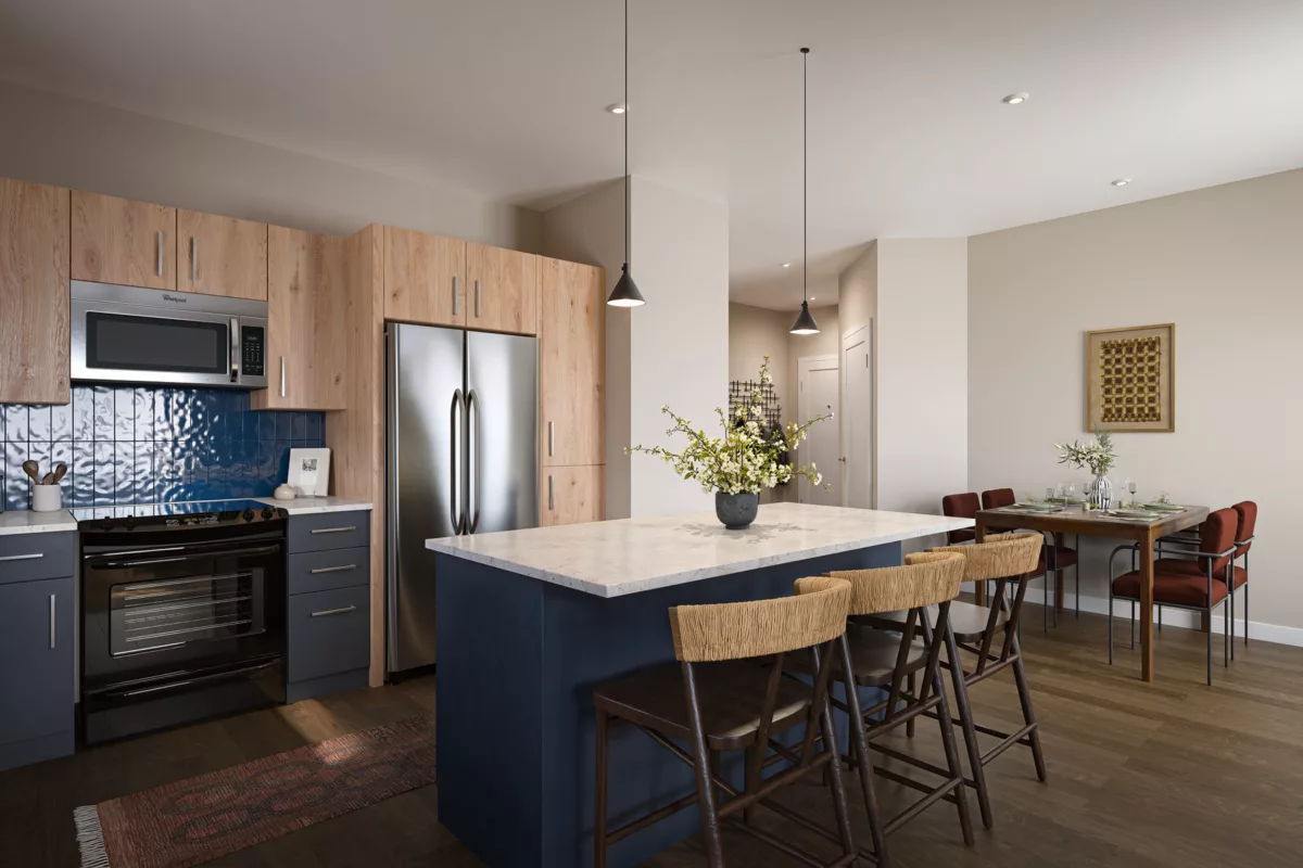 Modern kitchen with wood and blue cabinetry, stainless steel appliances, and a dining area.
