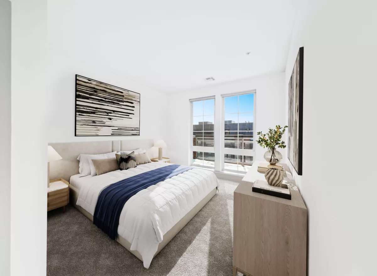 A modern bedroom with a large bed, two windows, and a light wood dresser with decor.