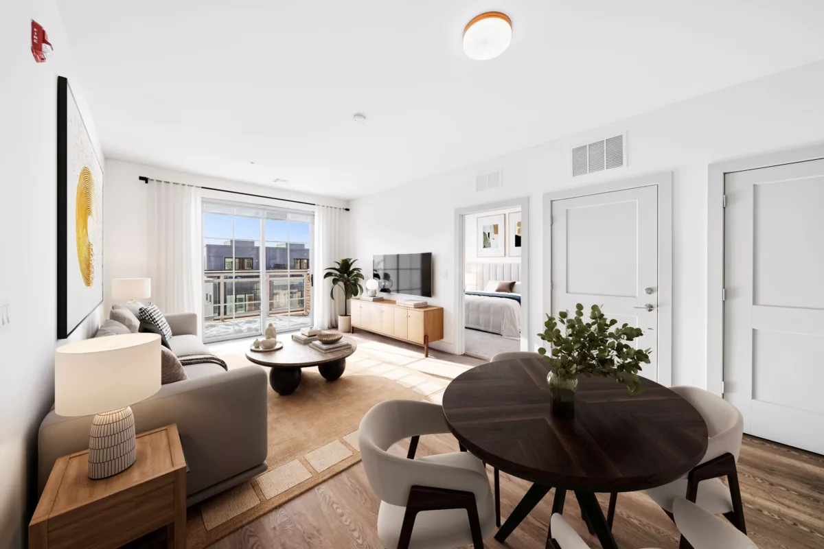 Open-concept living and dining area with wood-style flooring, a balcony, and a view into a bedroom.