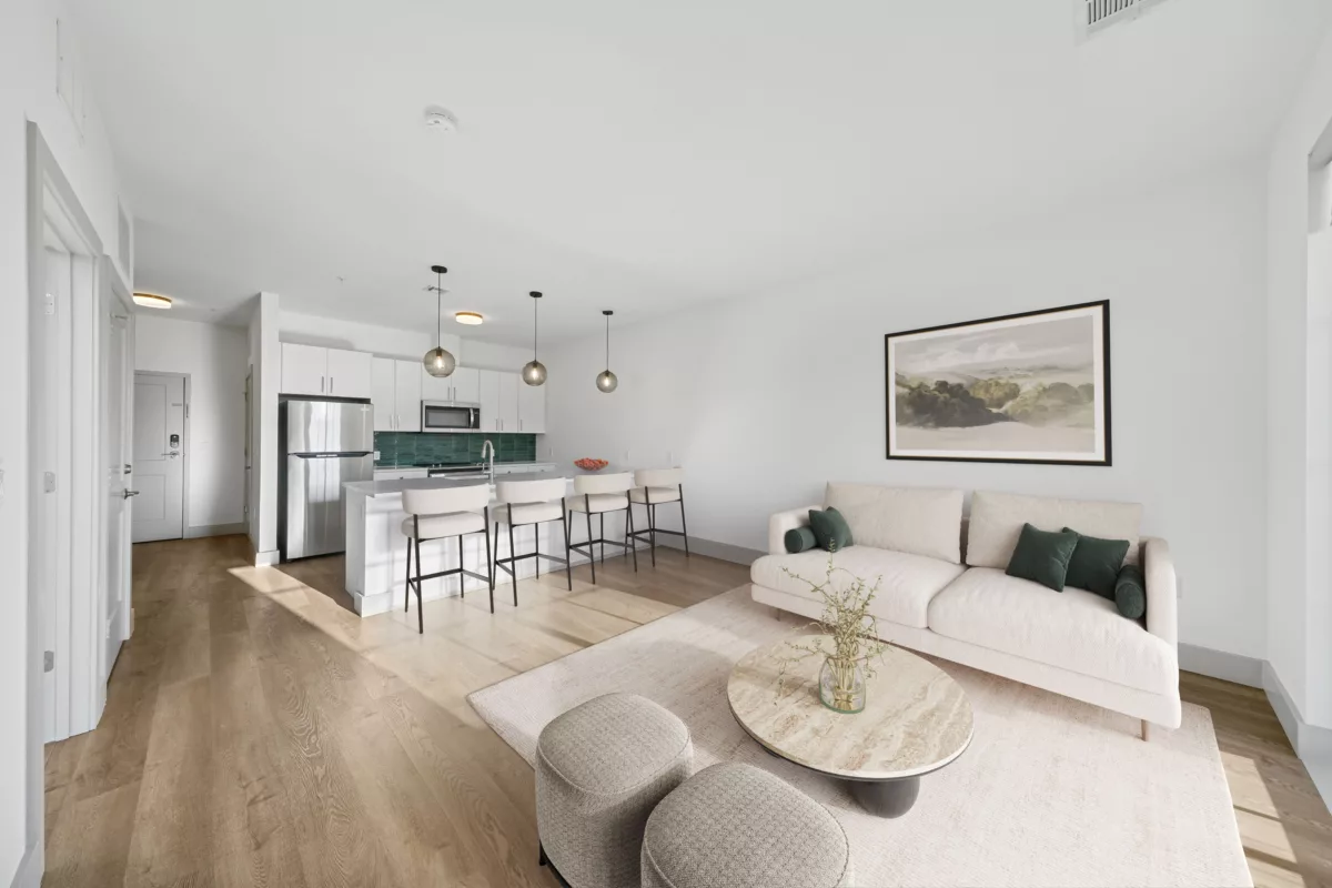 Open-concept kitchen with white cabinets, stainless steel appliances, and an island with bar seating.