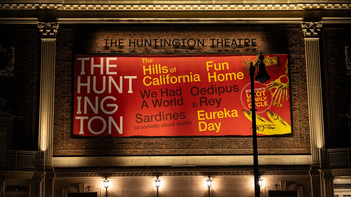 Red banner on theater facade listing show titles in yellow text.
