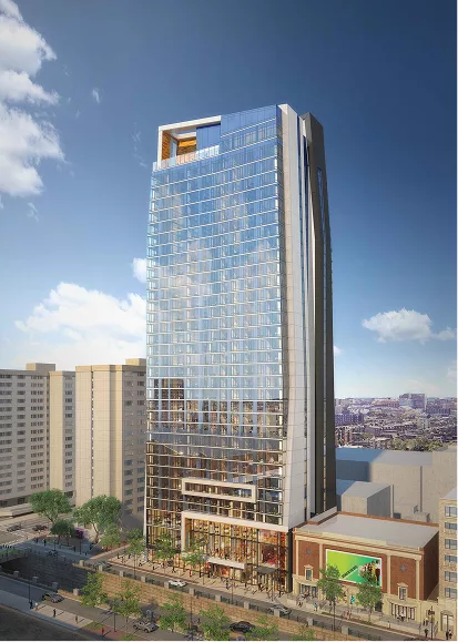 Tall modern glass skyscraper reflecting blue sky and nearby buildings.