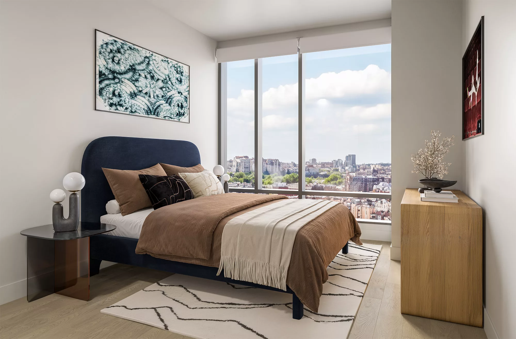 Bedroom with upholstered bed, artwork, and large window with city views