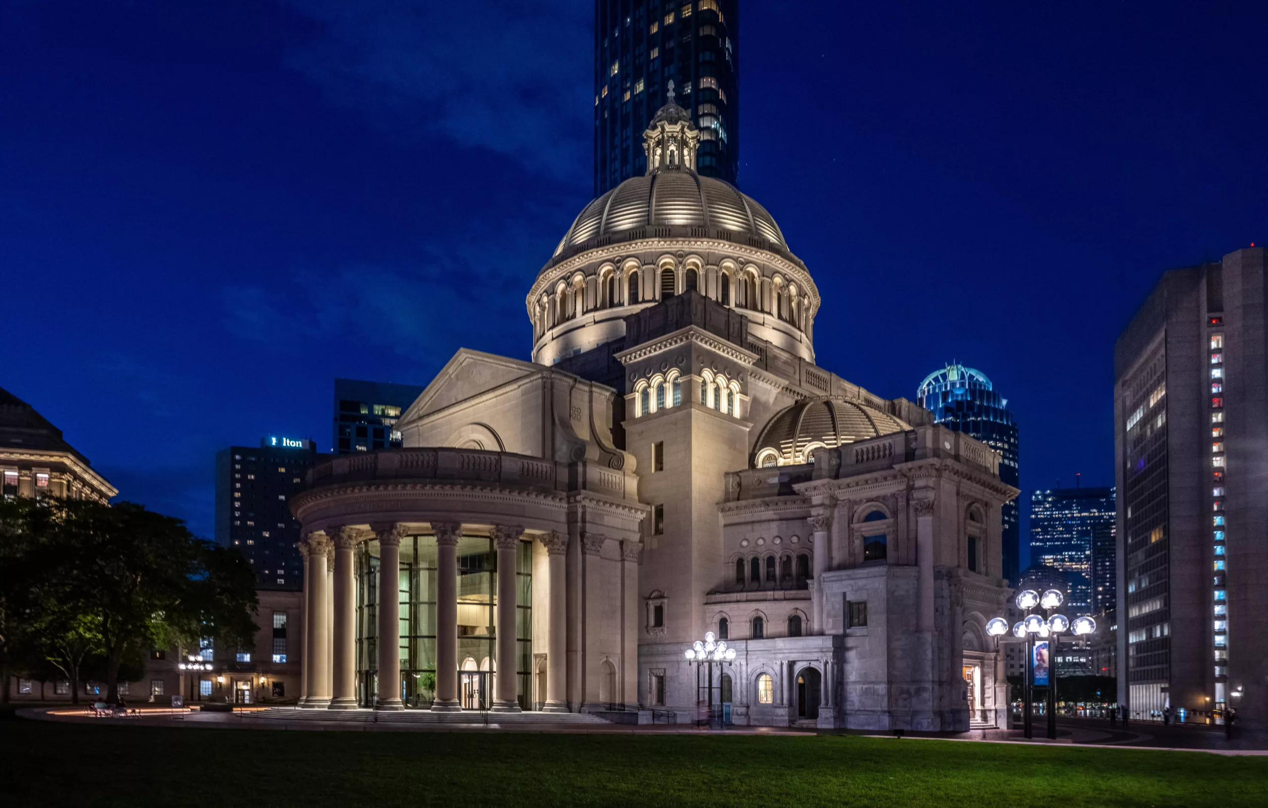 Illuminated domed church in Boston at night with surrounding city buildings