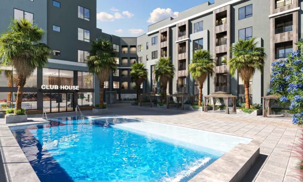 Pool courtyard with palm trees, cabanas, and “CLUB HOUSE” building entrance