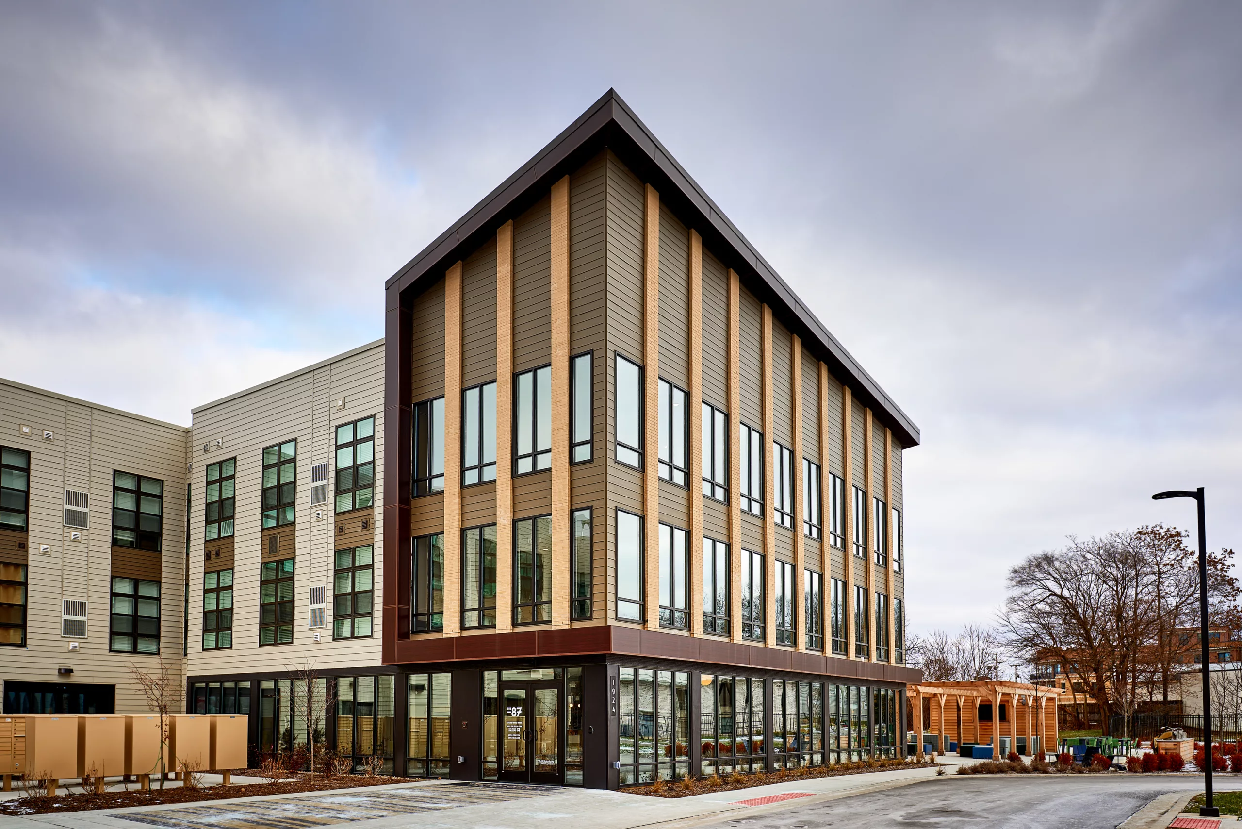 Modern three-story building with angled roof and large windows