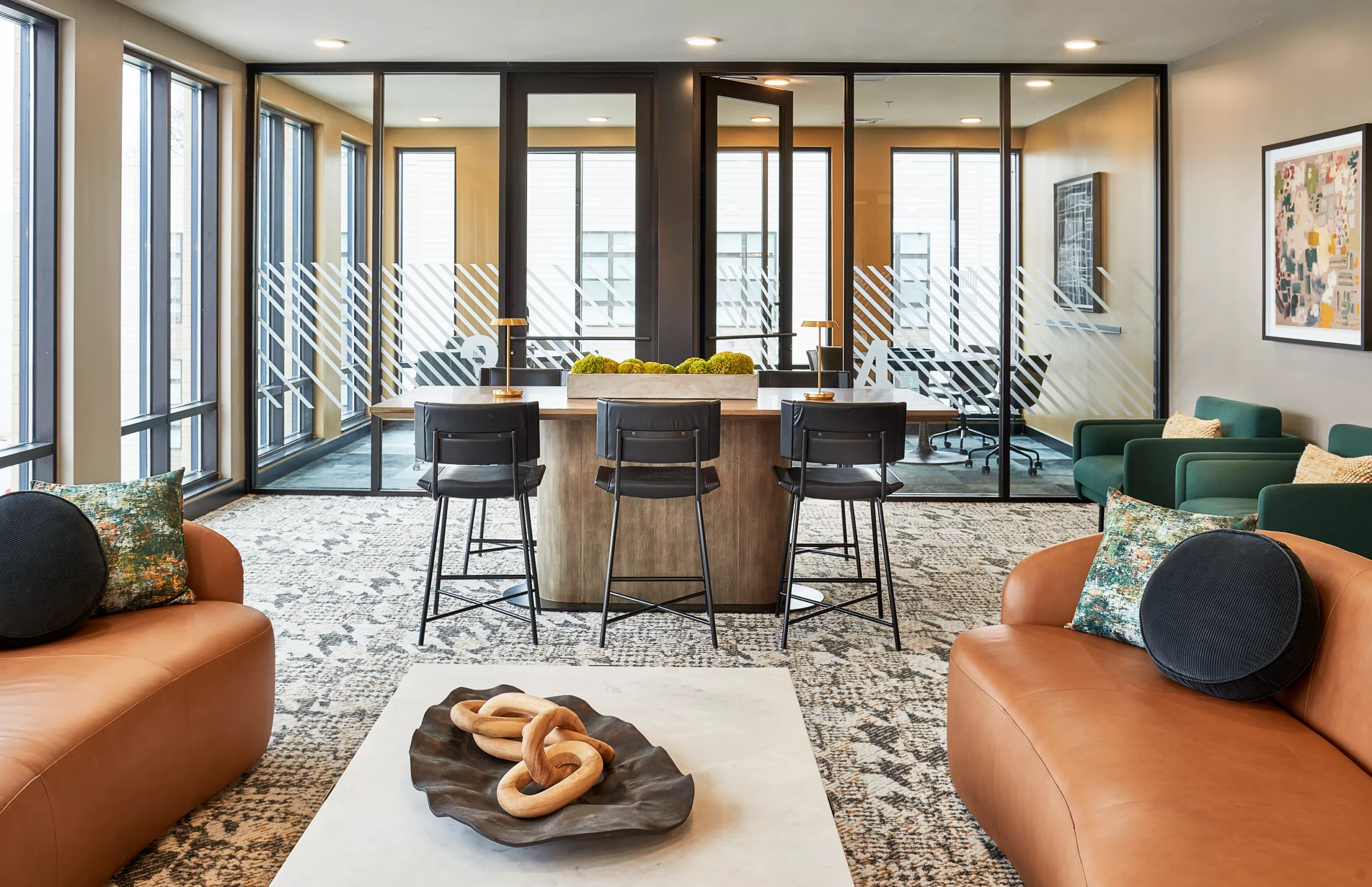 Coworking lounge with glass offices and modern decor