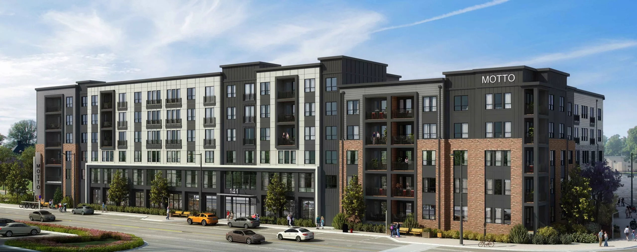 Modern five-story apartment building with a gray, black, and brick exterior, featuring balconies and street-level retail along a busy urban road.