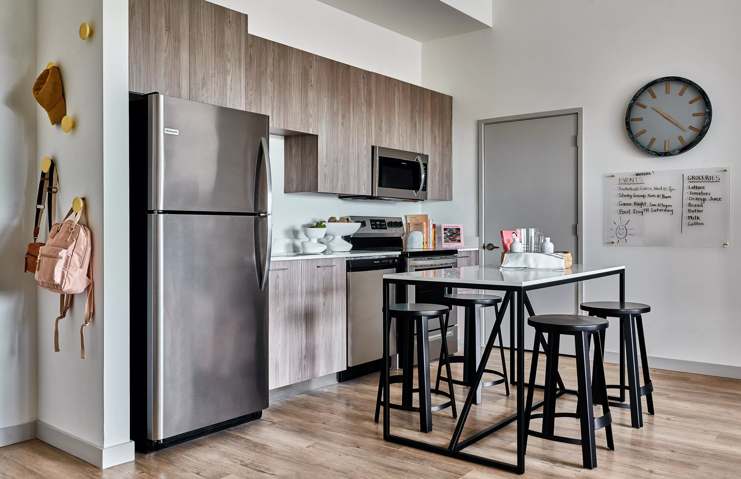 Compact kitchen with wood cabinets, bar table, and stainless steel appliances