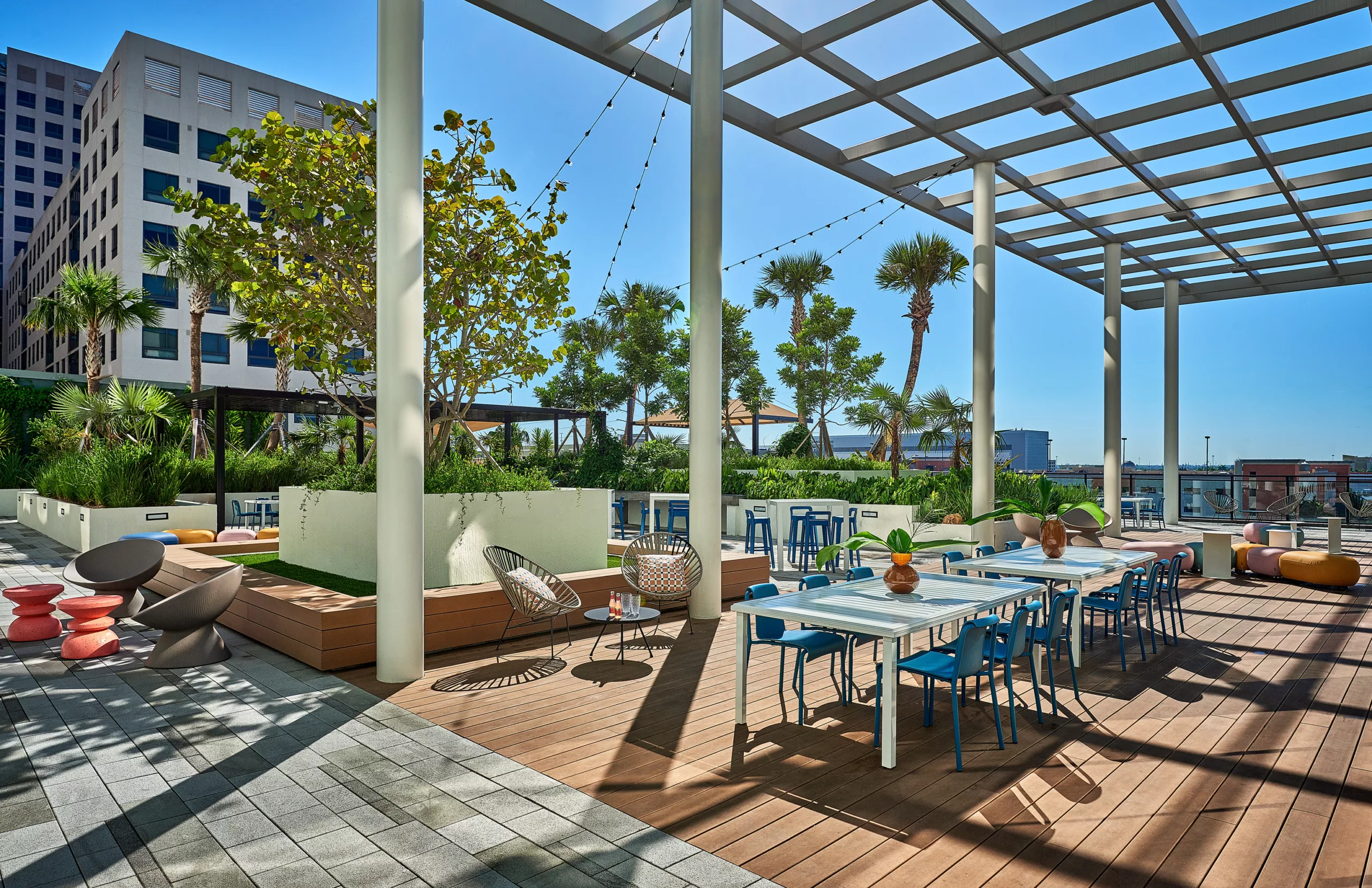 Outdoor patio with string lights, palm trees, and mixed seating areas
