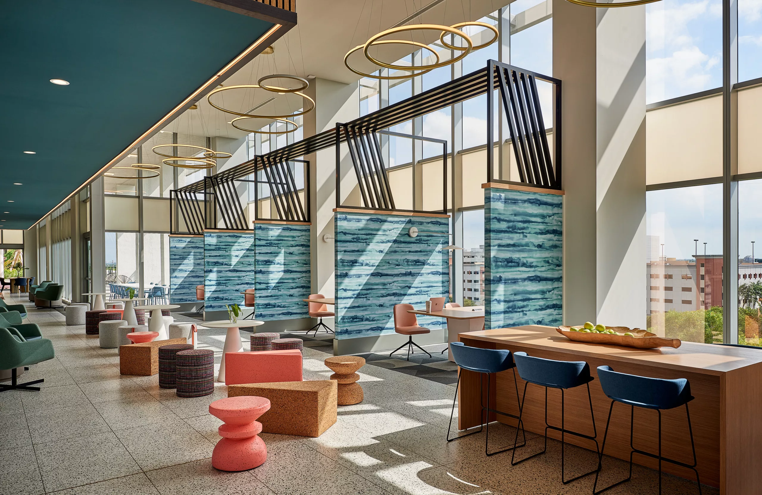 Coworking lounge with blue ceiling, modern lighting, and semi-private booths
