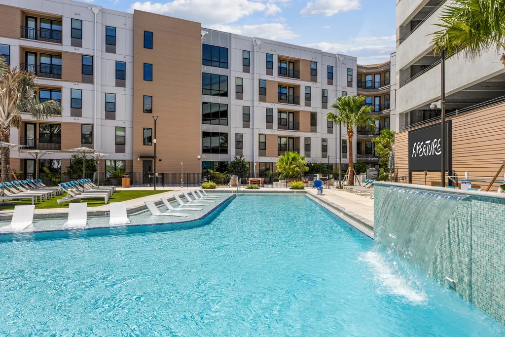 Outdoor pool with waterfall feature and lounge chairs