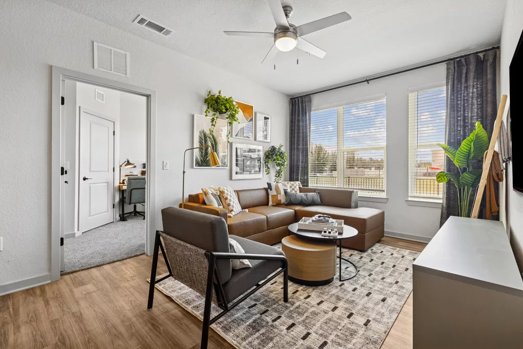 Living room with sectional sofa, armchair, and large windows
