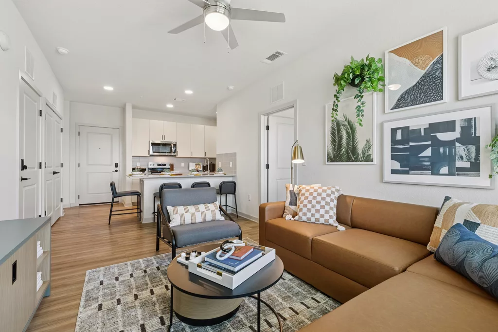 Open living space with kitchen, sofa, and wall art decor