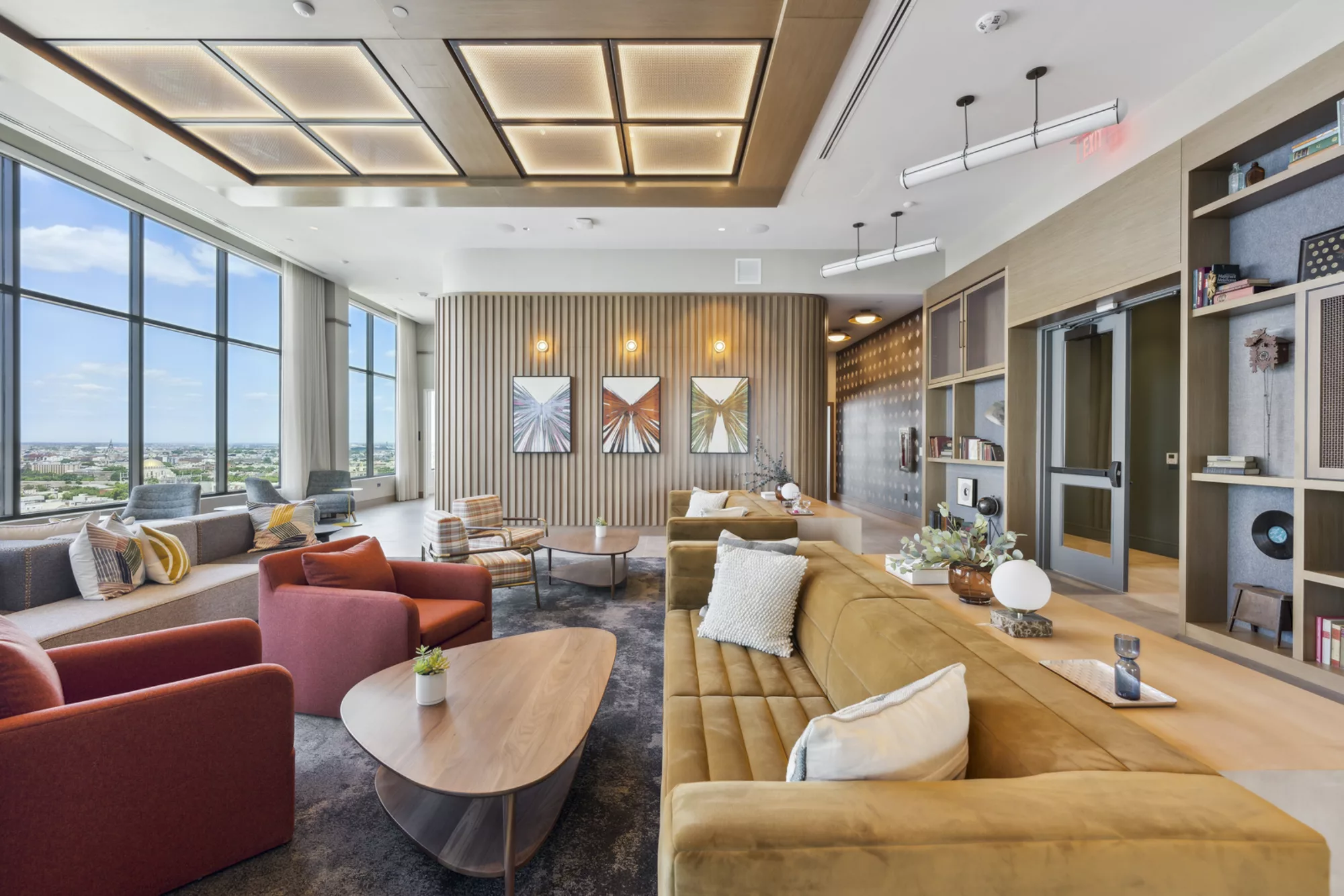 Modern lounge with large windows, artwork, and cozy seating
