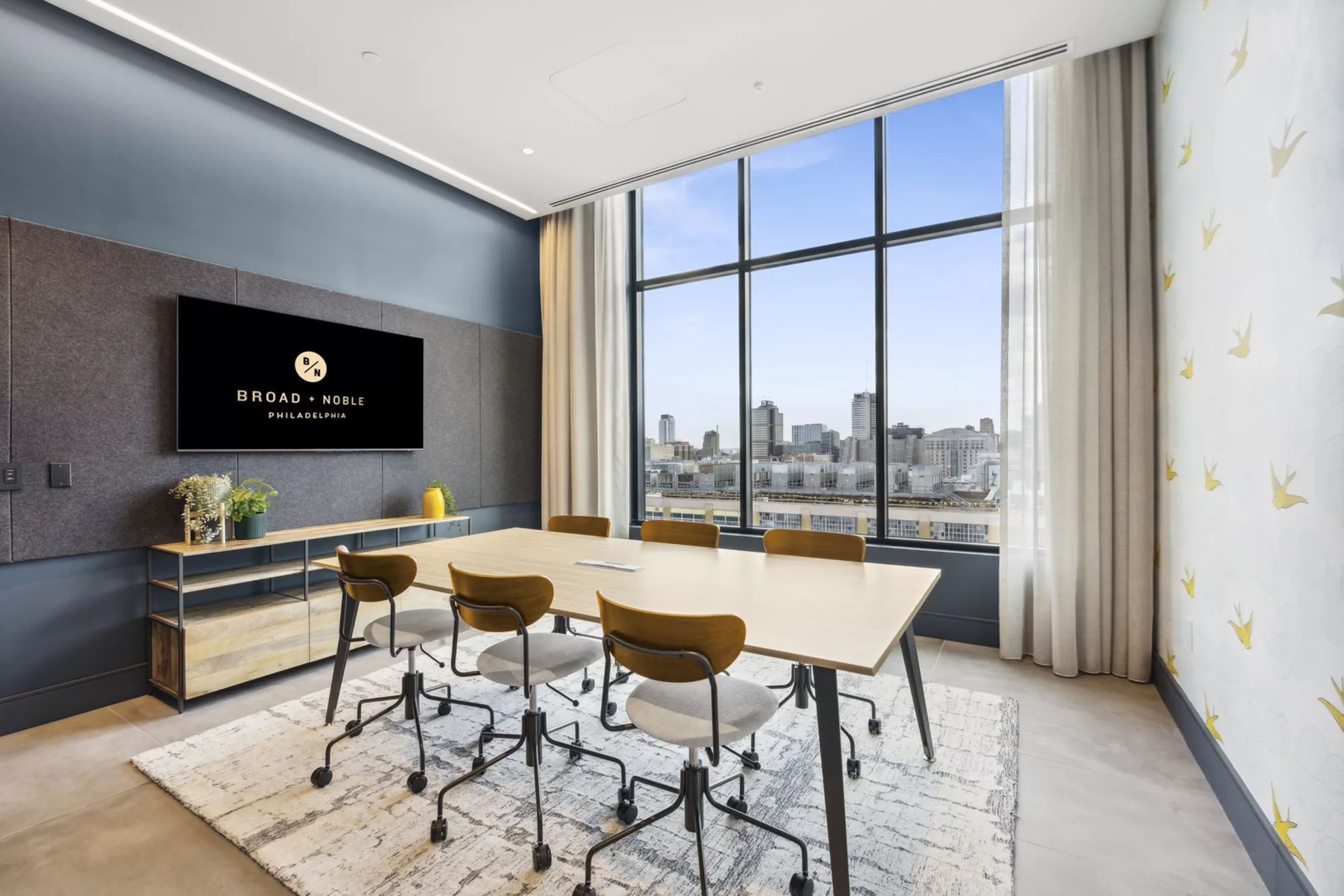 Conference room with table, chairs, and skyline view