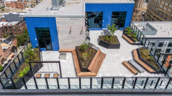 Rooftop terrace with benches, planters, swings, and glass railing