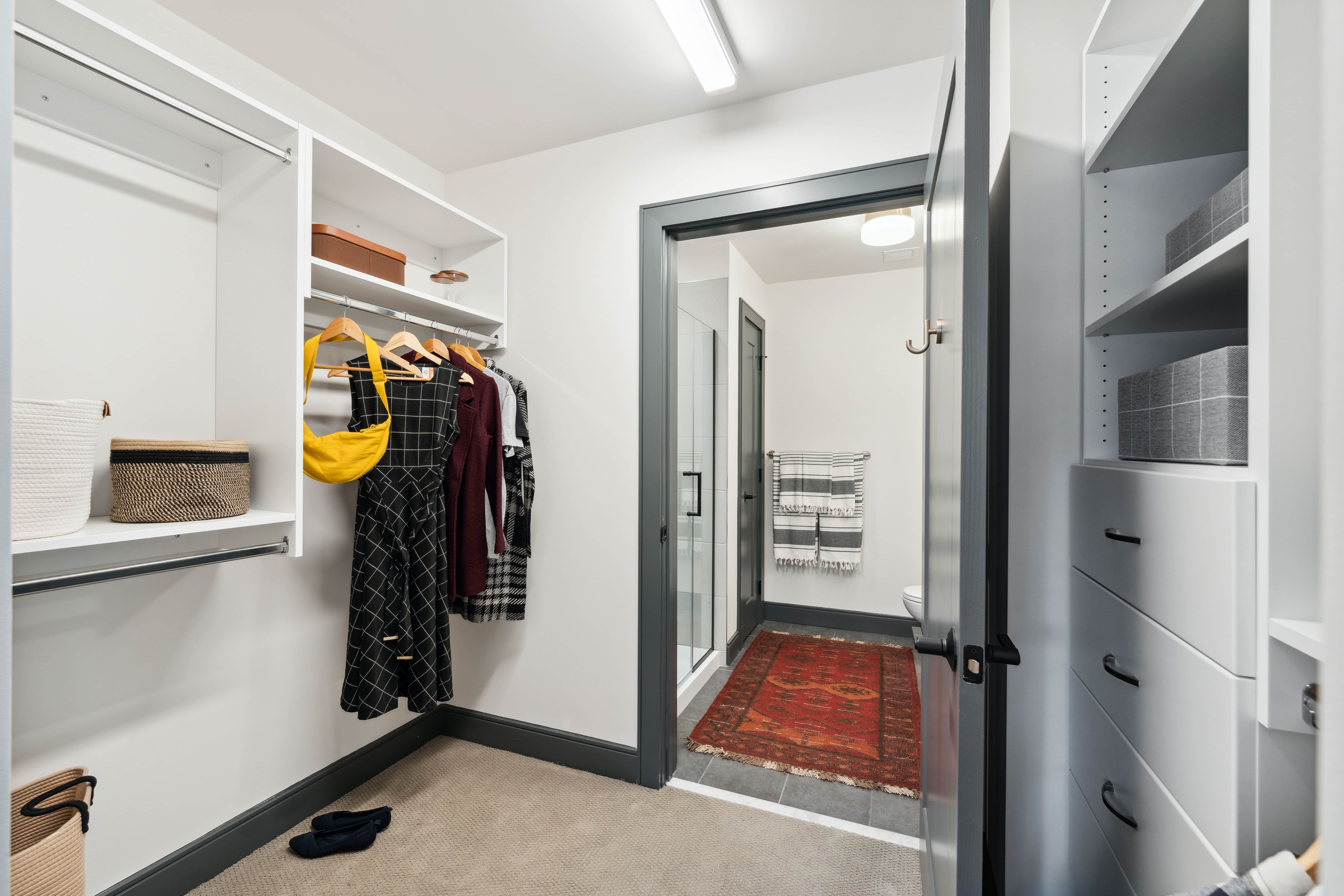 Walk-in closet with built-in shelves leading to bathroom