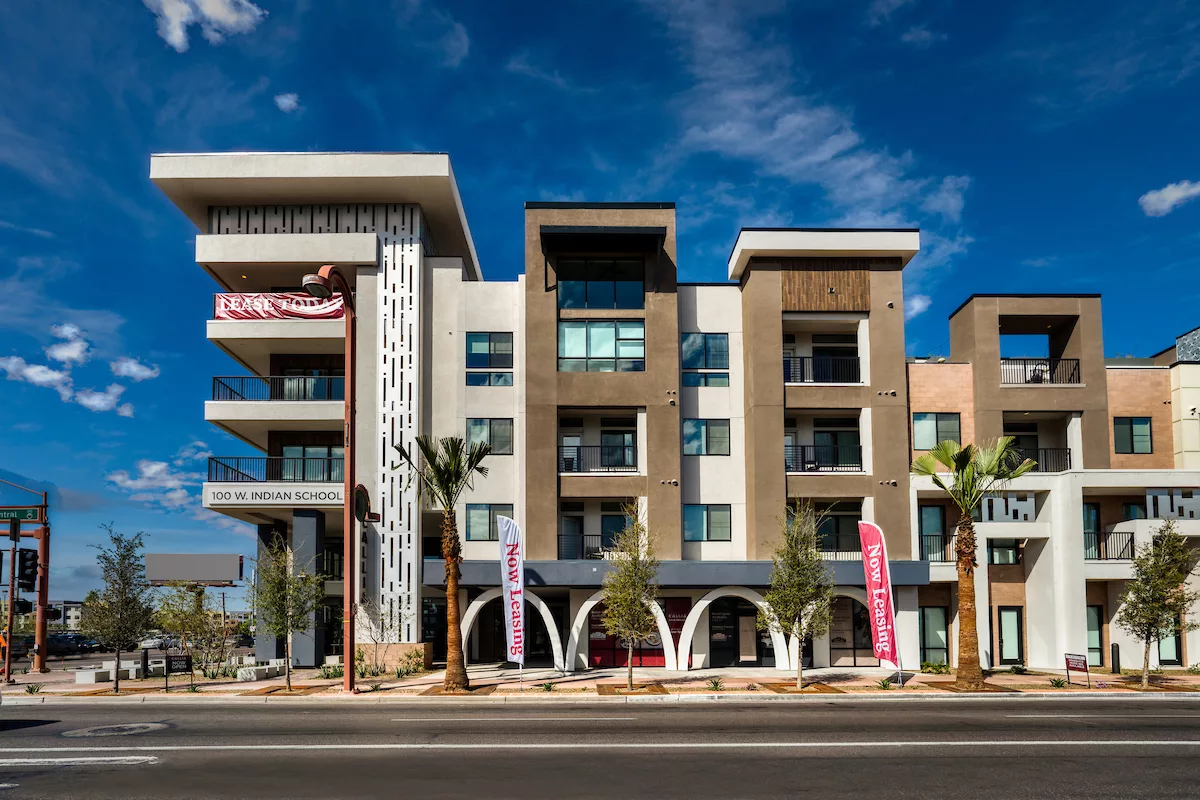 Street view of apartment complex with bold architecture and signage