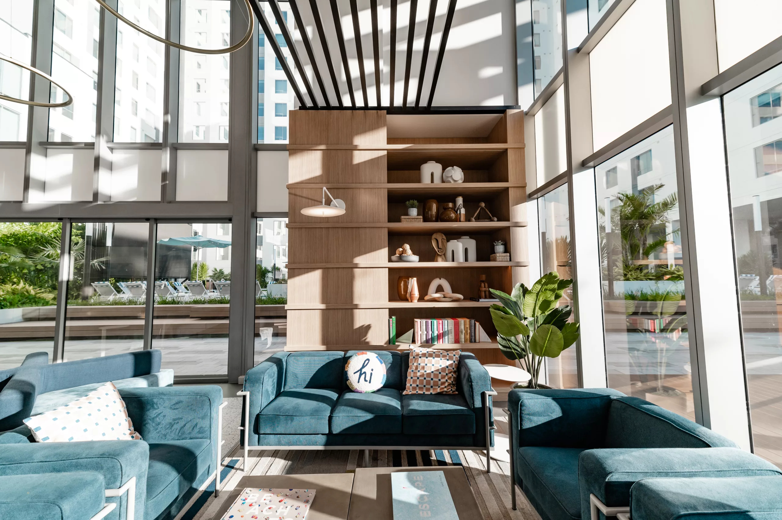 Coworking lounge with blue ceiling, modern lighting, and semi-private booths