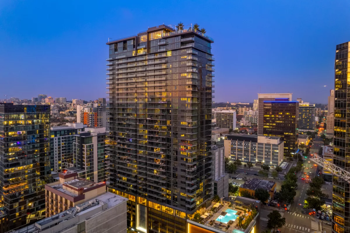 Glass high-rise building illuminated in evening cityscape